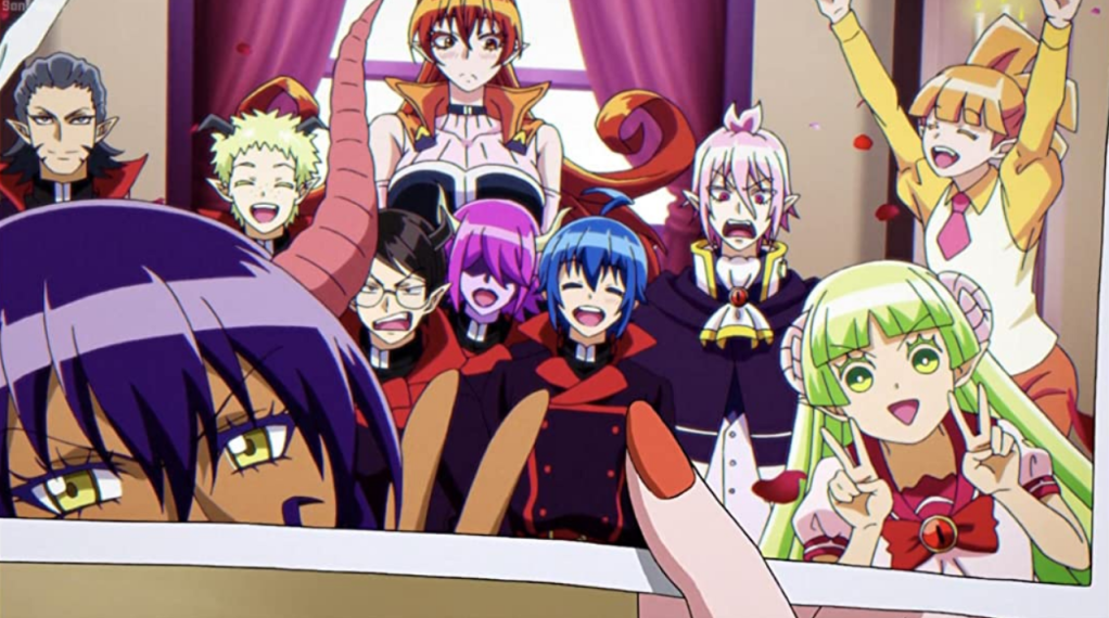 screenshot from welcome to demon school iruma-kun. a hand is holding a photograph of a group shot of several students and the student council.