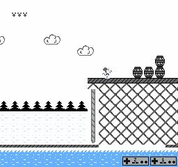 a screenshot of 8-bit mickey mouse on a series of platforms made of docks over a river, with barrels stacked on the dock.