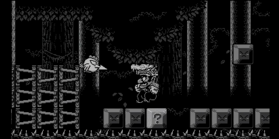 black and white screenshot of wario land. wario is in a jungle setting with a dragon hat, jumping on blocks 